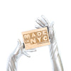 opera length metallic black vinyl gloves holding a wooden Made in NYC sign