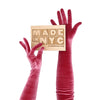 opera length burgundy velour gloves holding wooden Made in NYC sign