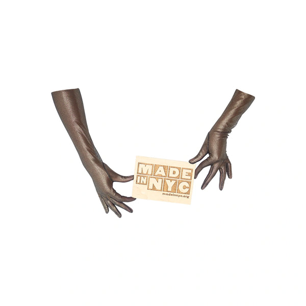 opera length metallic mesh black gold gloves holding Made in NYC wooden sign
