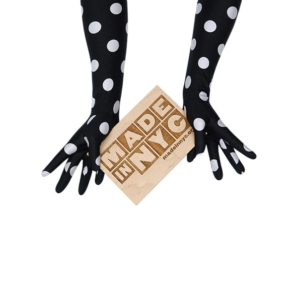 long black gloves with large white polka dots holding wooden Made in NYC sign
