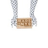 long white gloves with small black polka dots holding made in NYC wooden sign