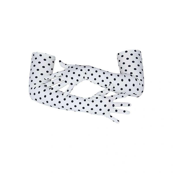 arms crossed wearing long white gloves with small black polka dots