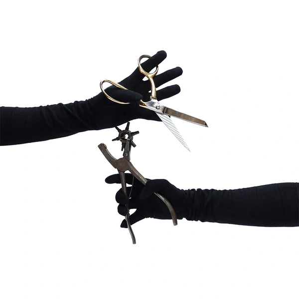 black suede gloves with left hand holding scissors and right hand holding pliers