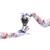 hands wearing long floral skull pattern gloves holding a mini silver skull