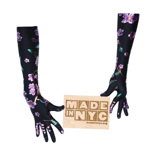 opera length black gloves with purple floral pattern holding wooden Made in NYC sign