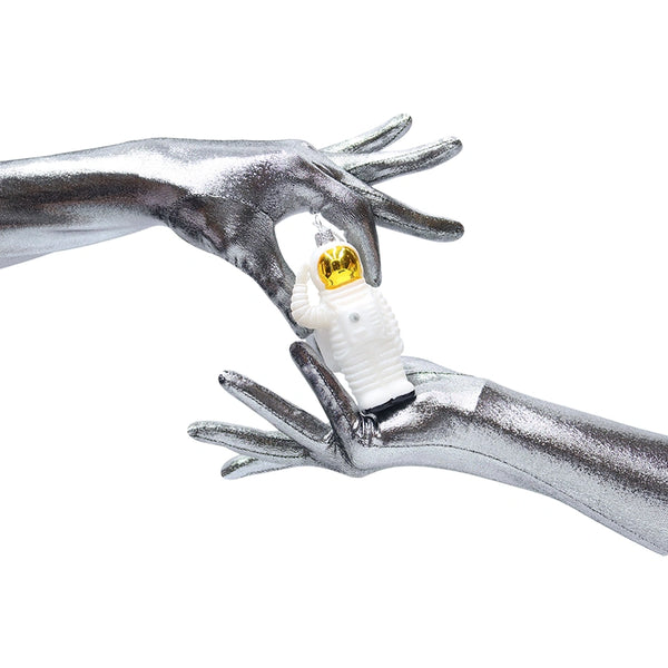 model wearing silver metallic spandex holding an astronaut toy