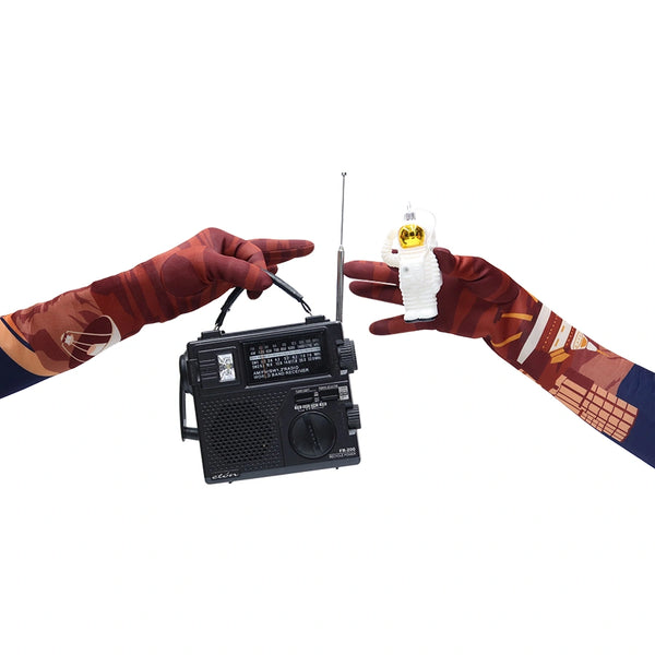 image of hands wearing illustrated outer space pattern gloves holding a mini stereo and astronaut ornament