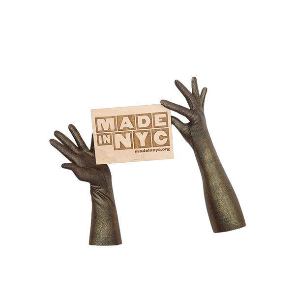 hand model wearing shimmery black gloves with a Made in NYC sign