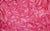 Detailed view of Natasha glove fabric swatch, made from 4-way stretch holo mini-dot spandex, in a golden hot pink color