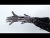 video of a model wearing black gloves with metallic embellishments