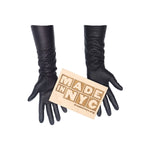 luxury black leather gloves holding wooden Made in NYC sign
