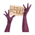 model wearing sequin gloves holding the madeinnyc.org sign