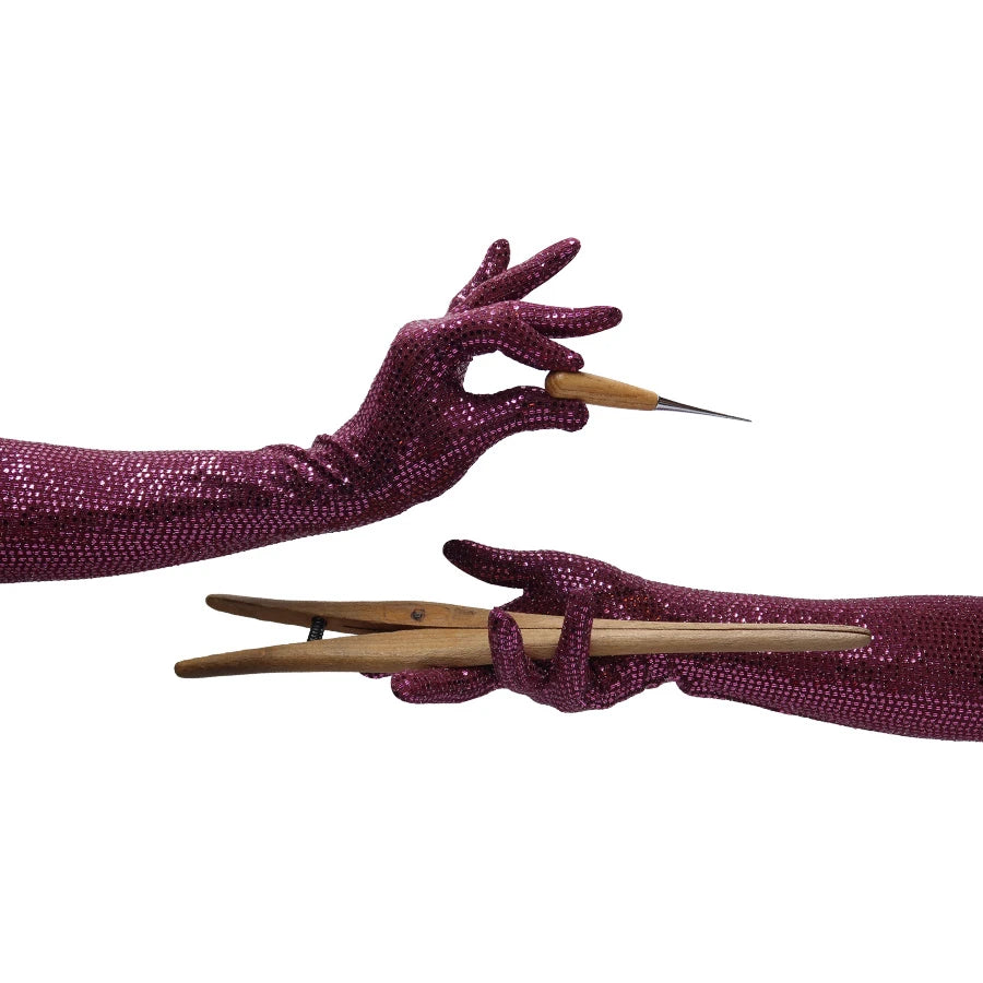 model wearing purple sequin gloves holding wooden tools